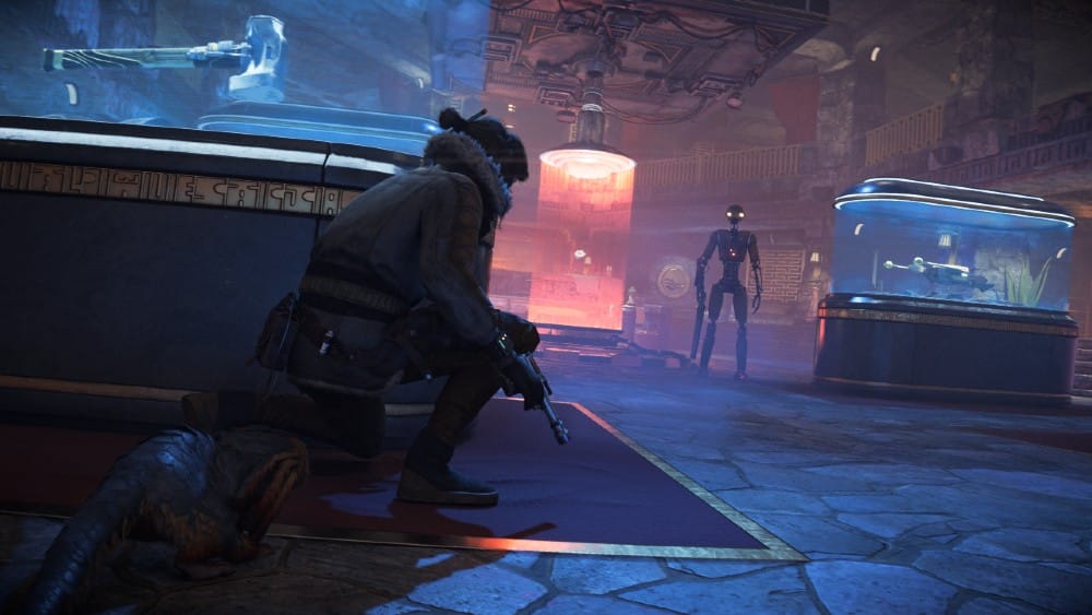 Kay takes cover in a futuristic museum, aiming a weapon at an approaching robotic figure. Star Wars Outlaws-themed displays are visible in the background.