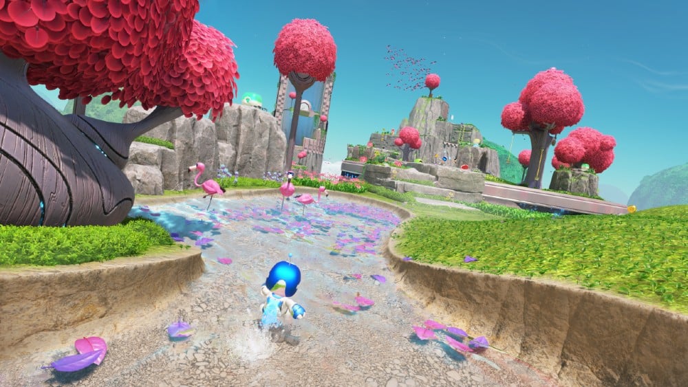 Astro Bot runs on a path amidst colorful pink trees, flamingos, and butterflies in a fantasy landscape.