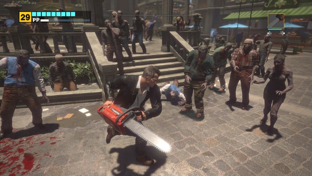 In the Dead Rising Deluxe Remaster, Frank West battles hordes of zombies with a chainsaw in a mall, showing a crowd of zombies on stone steps and pavement.