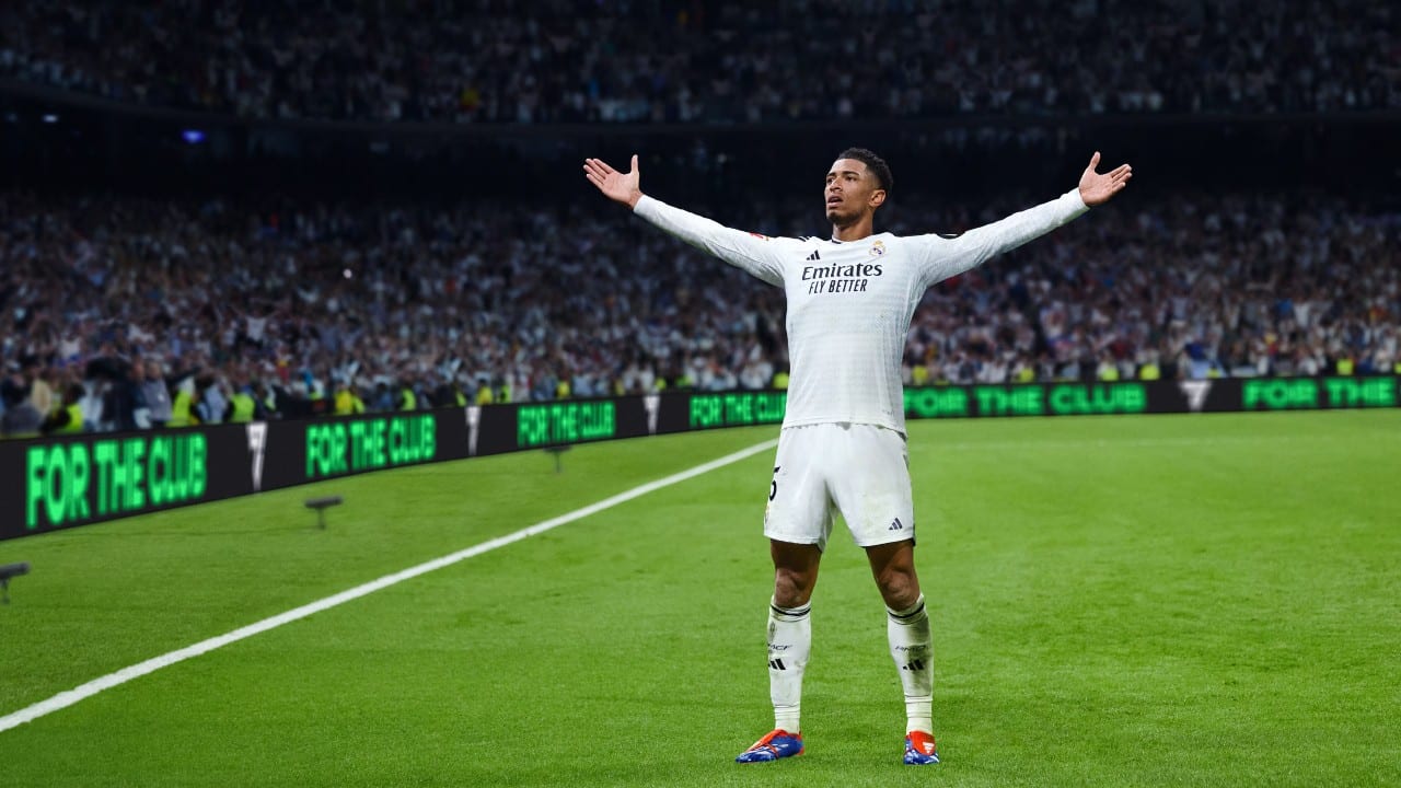 A soccer player in a white uniform celebrates on the field with arms raised, the stadium crowd erupting in the background. It’s a moment captured perfectly in EA Sports FC 25.