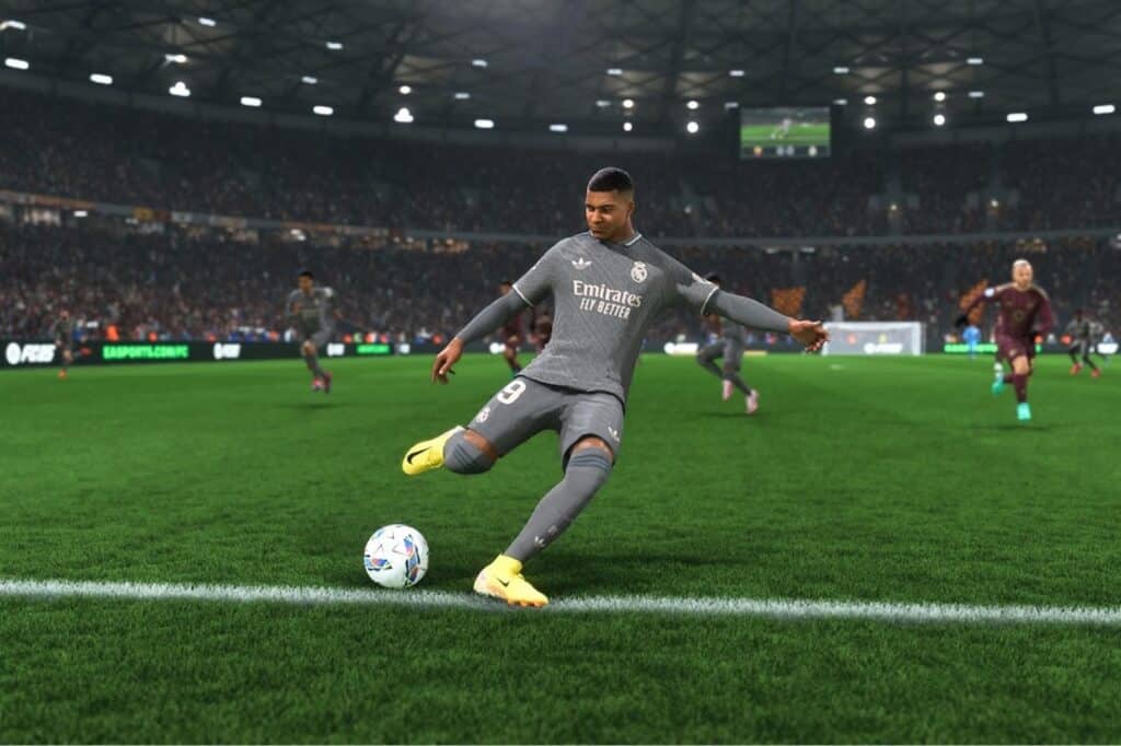 Soccer player in gray uniform kicking the ball mid-game in a packed stadium with bright lights, reminiscent of an epic moment from EA Sports FC 25.