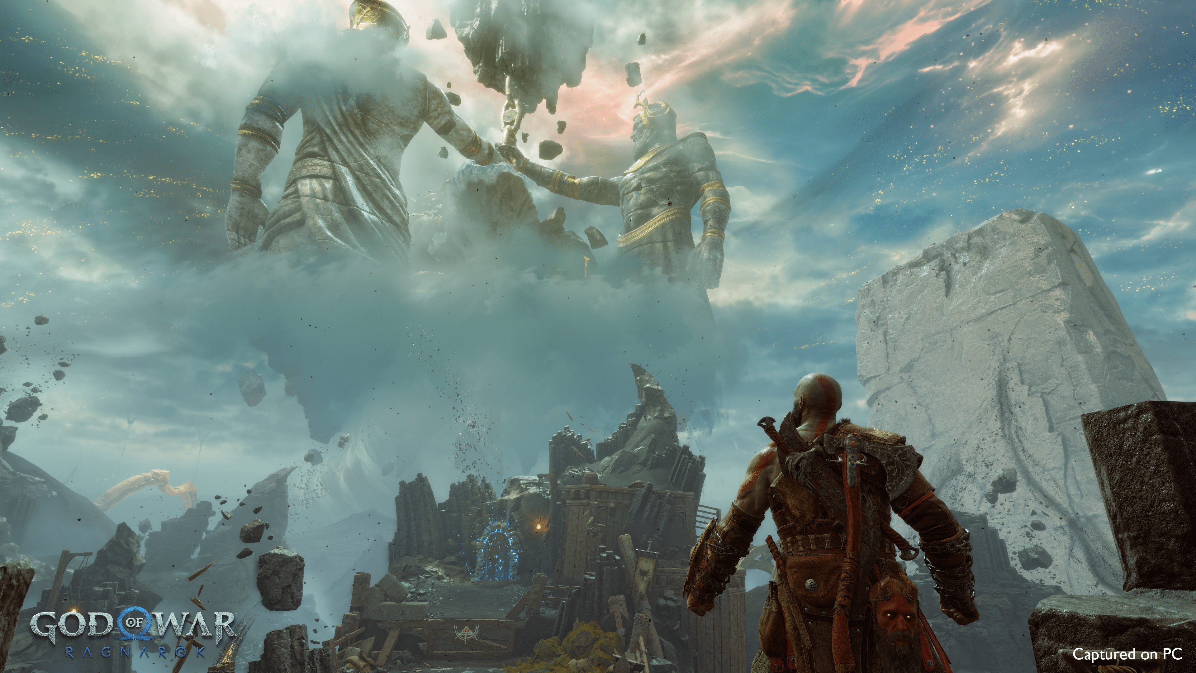 Kratos gazes at colossal statues holding a glowing object amidst a dramatic, mythic landscape in God of War Ragnarök.