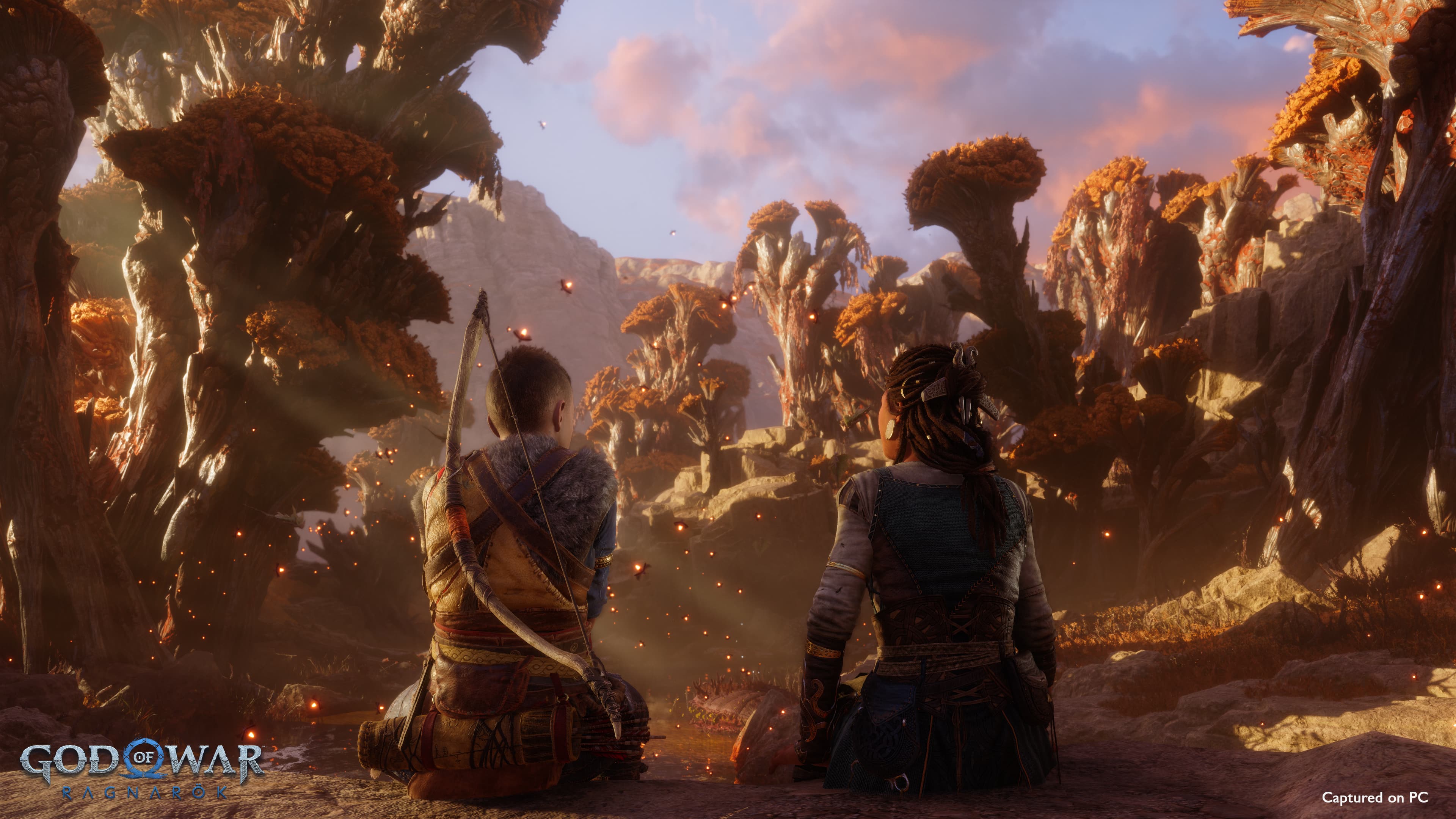 Two characters from "God of War Ragnarök" sit together, overlooking a fantastical landscape with unusual tree formations.