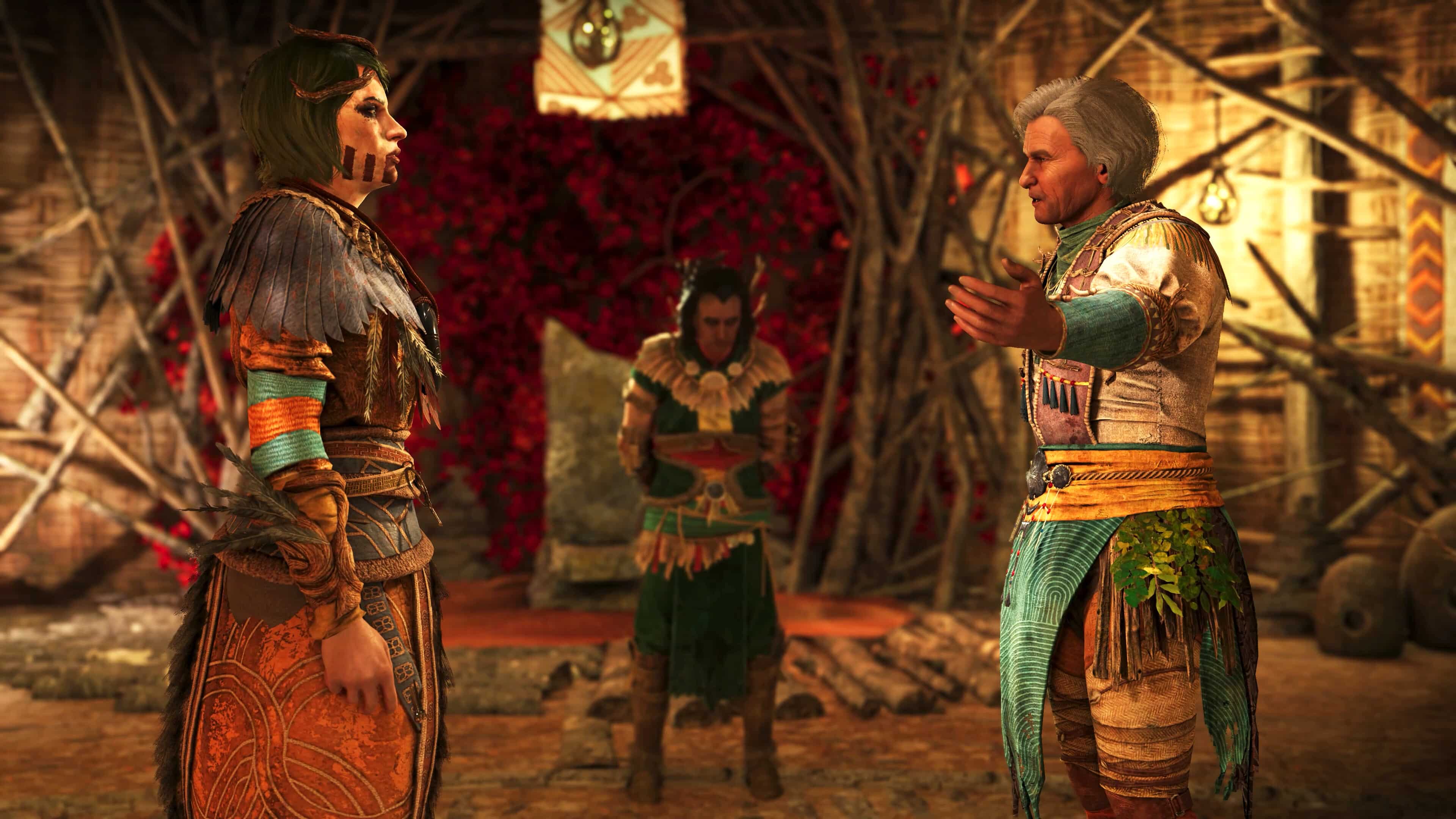 In a rustic room, three people in tribal clothing engage in a deep discussion, highlighted by the vivid red leaves in the background, just like a scene from GreedFall II: The Dying World.