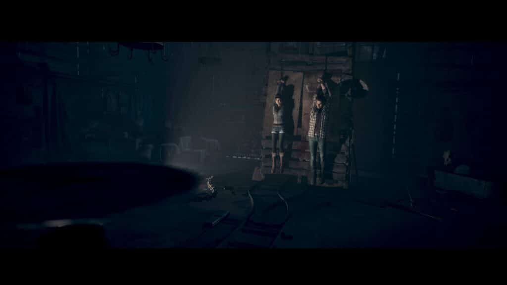 A scene from Until Dawn (2024), the dark, eerie room looms with figures hauntingly suspended from the ceiling and scattered debris littering the floor.