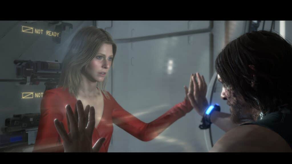 A woman in a red dress and a man with a blue wristband face each other, separated by glass, evoking the enigmatic world of Death Stranding Director’s Cut.