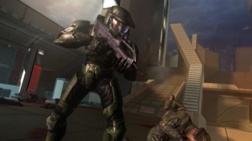 In a futuristic setting reminiscent of Halo 2's iconic battles, an armored soldier crouches near the stairs, rifle at the ready, with another comrade poised nearby as they mark the game's 20th anniversary.