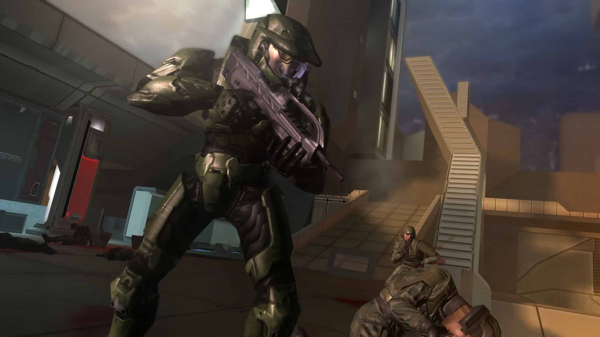 In a futuristic setting reminiscent of Halo 2's iconic battles, an armored soldier crouches near the stairs, rifle at the ready, with another comrade poised nearby as they mark the game's 20th anniversary.