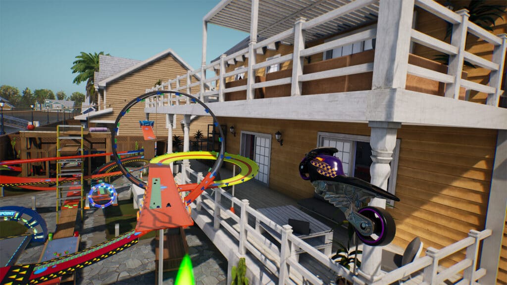 Vibrant loops and toy race tracks from Hot Wheels Unleashed 2: Turbocharged are set up on a wooden porch, framed by railings and a sunny backdrop.