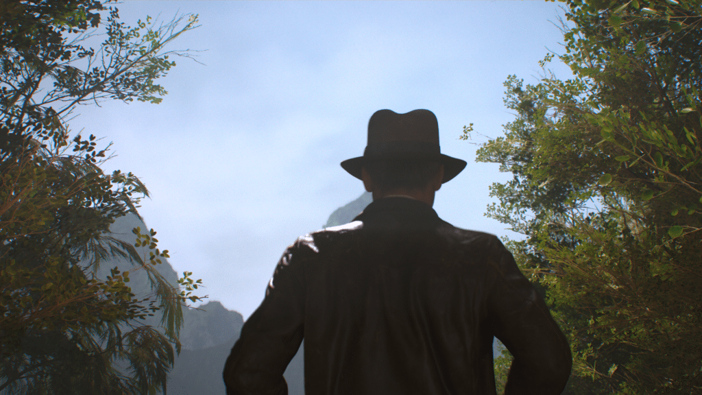 Indiana Jones in a hat and jacket stands in a lush, dense forest, looking at a bright, clear sky.