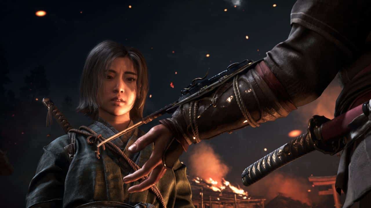 In the dimly lit, fiery background, a warrior clad in traditional Japanese armor gazes at a sword, evoking the atmosphere of Assassin’s Creed Shadows.