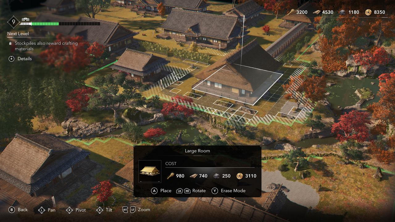 A bird's-eye view of a video game village, reminiscent of Assassin's Creed Shadows, showcases autumn trees and a strategic building placement interface on the screen.