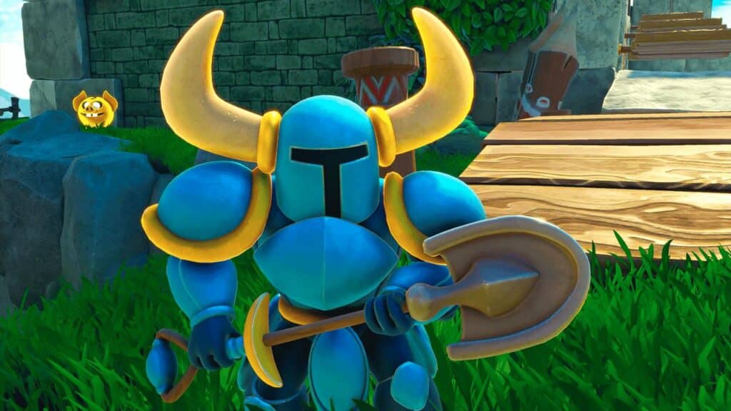 In a surprising twist, the blue-armored knight with large horns makes a grand return in Yooka-Replaylee, holding his iconic shovel while standing on grass near an ancient stone wall.