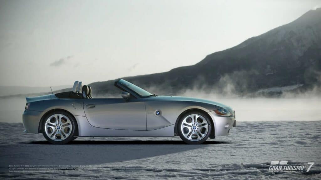 Convertible car parked on a snowy landscape with misty mountains in the background, perfectly capturing the essence of Gran Turismo 7 update 1.56. Text: "Gran Turismo 7.