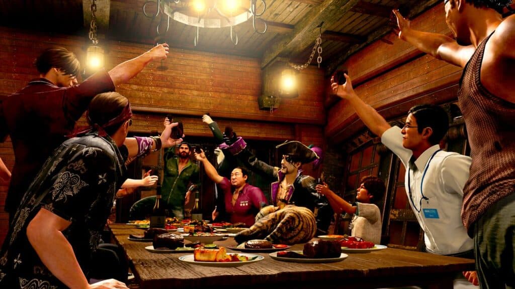 A group of people in a rustic room, reminiscent of a scene from *Like a Dragon: Pirate Yakuza in Hawaii*, raises glasses in a spirited toast around a table laden with food. A cat, strikingly nonchalant amidst the lively atmosphere, sits calmly on the table.