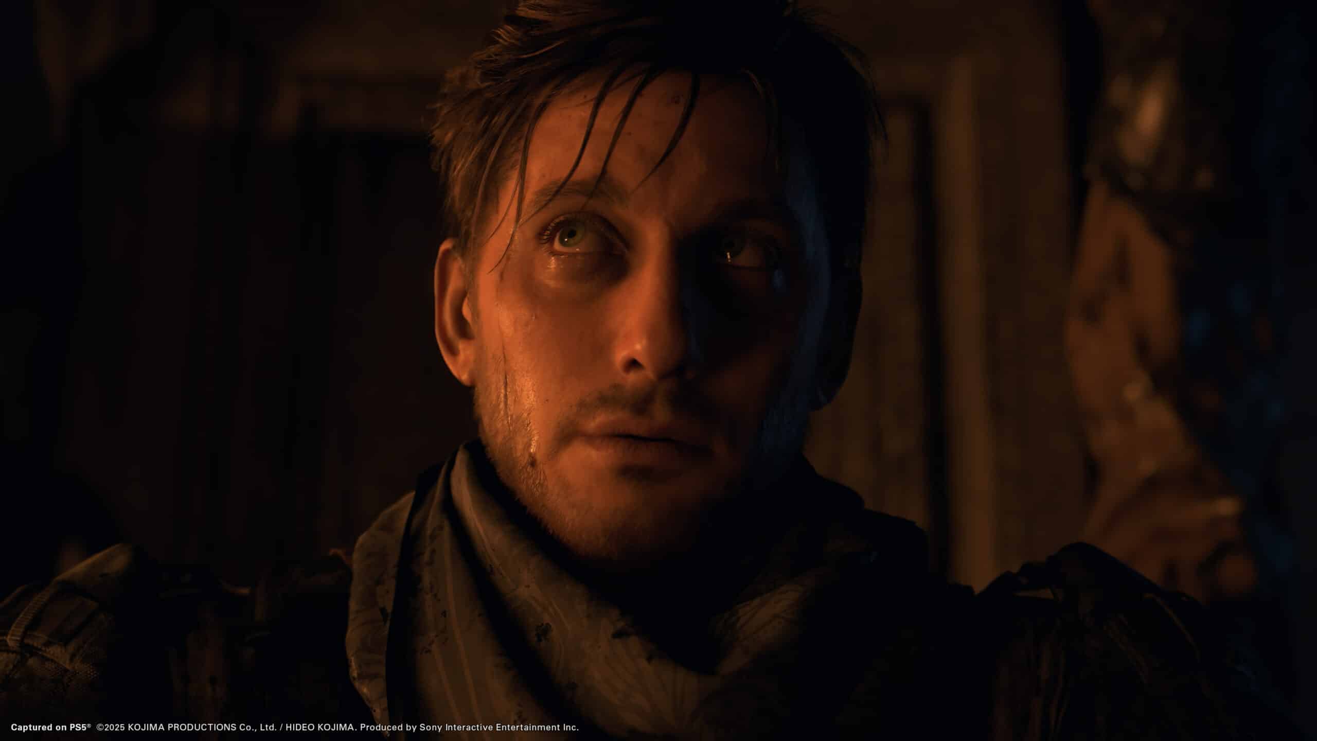 A solemn man with tousled hair and a scarf stands in dim lighting, reminiscent of a character quietly awaiting the Death Stranding 2 launch date, gazing slightly upward.