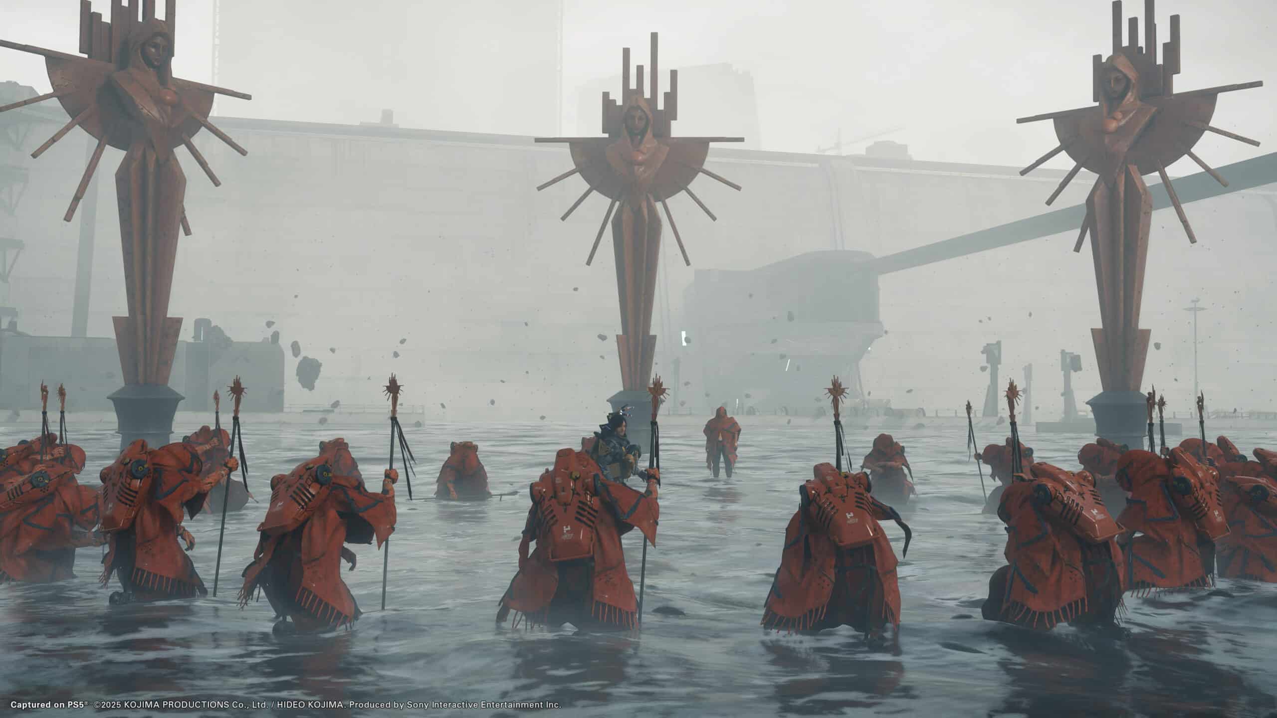 Figures in red robes wade through the water, holding staffs near large statues with crosses and abstract symbols, creating an atmosphere akin to a scene from Death Stranding 2.