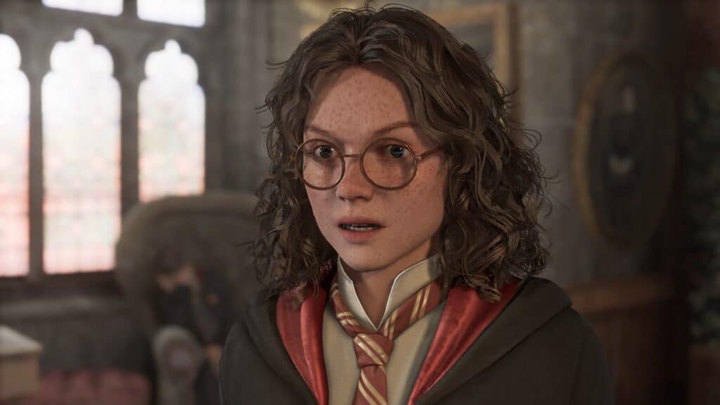 A young person with curly hair, glasses, and a robe stands indoors looking surprised, as if they've just discovered Hogwarts Legacy on Nintendo Switch 2.