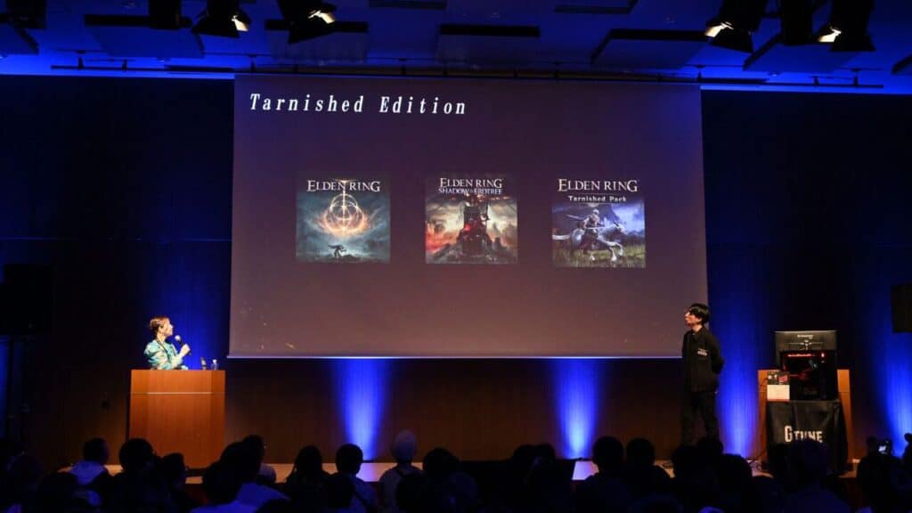 Two presenters stand on stage showing Elden Ring Tarnished Edition Nintendo Switch 2 covers on a large screen to an eager audience.