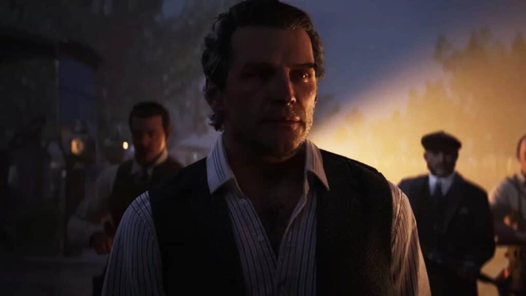 A serious man in a vest stands in the foreground with three men blurred behind him at night, evoking the atmosphere of Mafia: The Old Country PAX East panel.