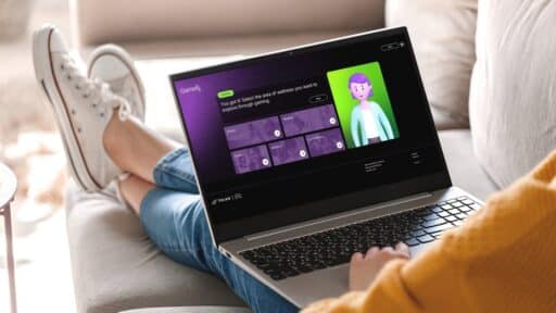 Person sitting on a couch using a laptop with an animated online learning module from the GameRx wellness gaming platform on the screen.