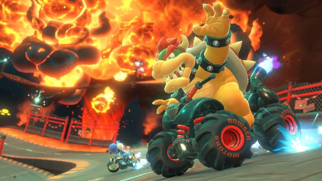 Bowser races a large ATV on a fiery track in Mario Kart World, with flames and fellow racers blazing in the background.