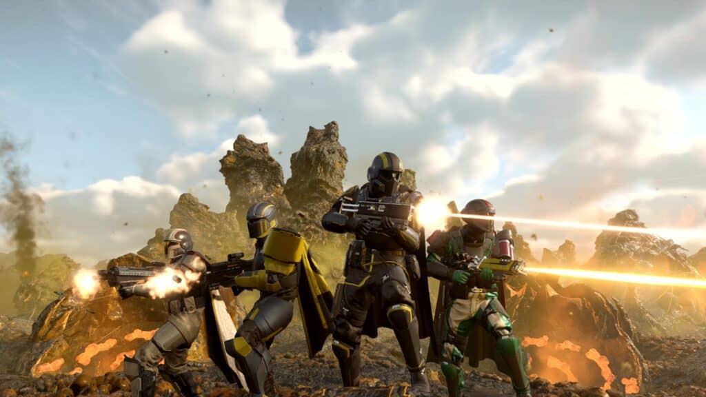 Four armored sci-fi soldiers fire glowing weapons on a rocky, alien battlefield under a cloudy sky, evoking the intense action fans will see in a Helldivers 2 Xbox release.