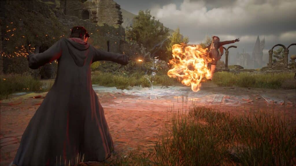 Two wizards duel outdoors, one casting a fiery spell at the other in a ruined, castle-like setting reminiscent of Hogwarts Legacy.