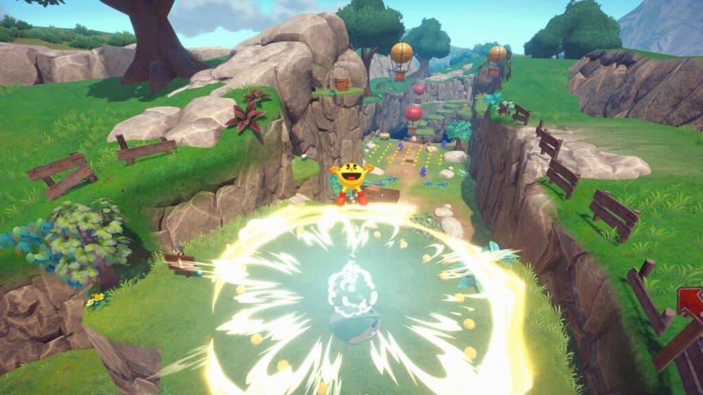 Pac-Man leaps through a colorful 3D landscape in PAC-MAN WORLD 2 Re-PAC, creating a bright shockwave with coins and balloons ahead.