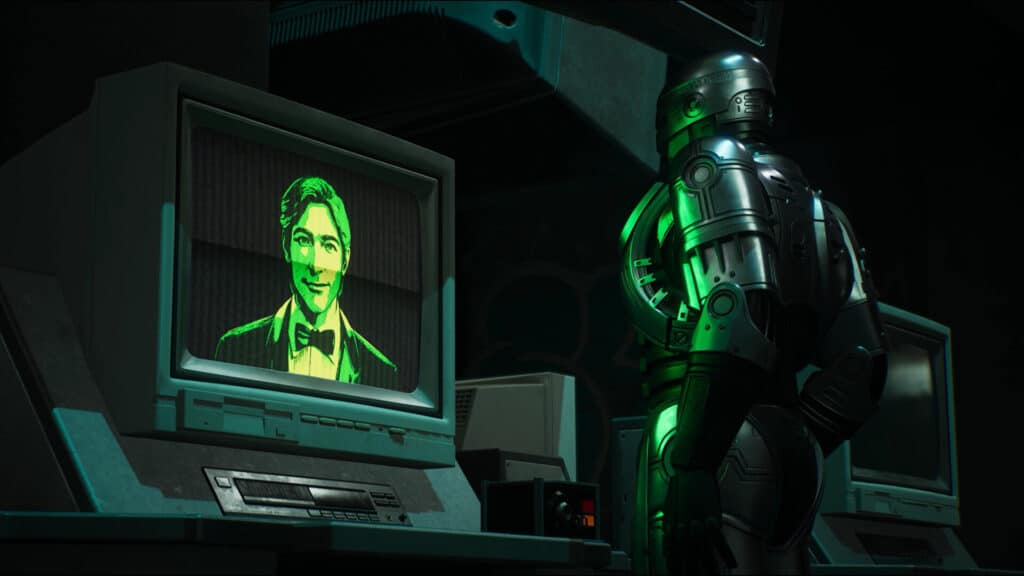 RoboCop stands by an old computer displaying a green-tinted man's face on the monitor, hinting at unfinished business in RoboCop Rogue City Unfinished Business.