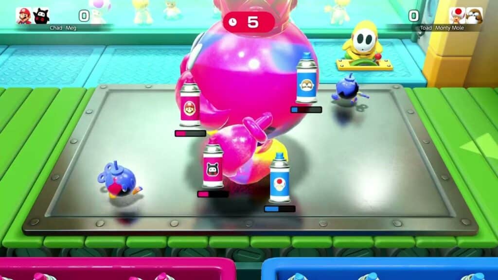 Four paint cans and two blue wind-up creatures surround a large pink balloon in a colorful Super Mario Party Jamboree game setting.