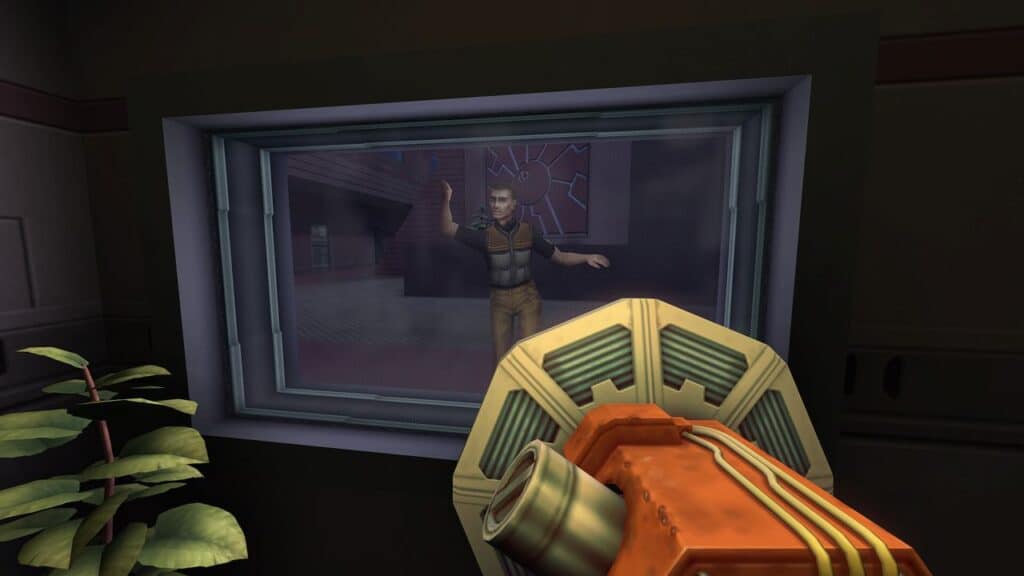 A person stands behind glass waving, viewed from behind a sci-fi device inside a dimly lit room—evoking the eerie atmosphere of the System Shock 2 25th Anniversary Remaster.