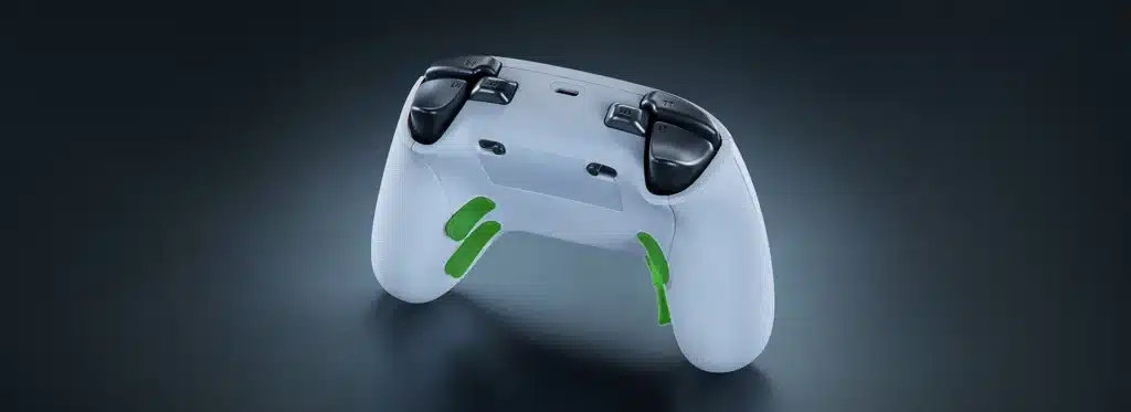 White gaming controller with black triggers and two green rear paddles, shown on a dark surface.