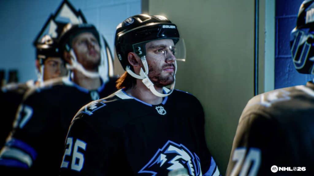 Hockey players in black jerseys line up in a hallway as the EA Sports NHL 26 logo is visible in the corner.
