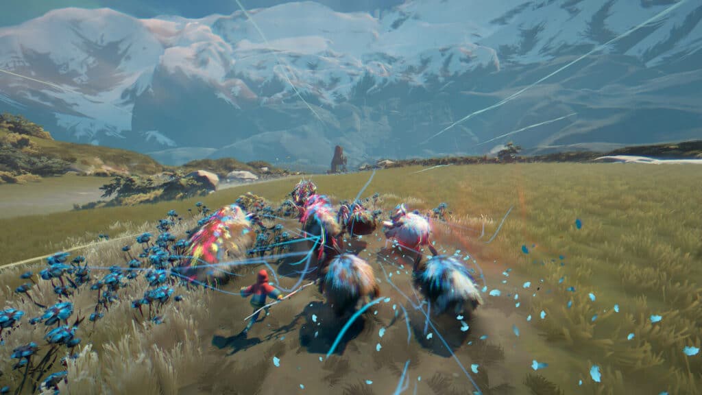 A group of colorful Herdling animals run through a grassy field with blue flowers under snowy mountains.