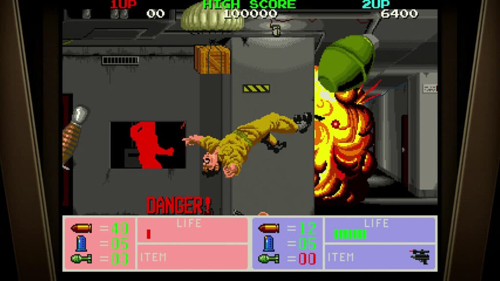 Arcade game scene from Operation Night Strikers: soldier thrown by explosion, “DANGER!” warning flashing, with health bars and scores displayed.