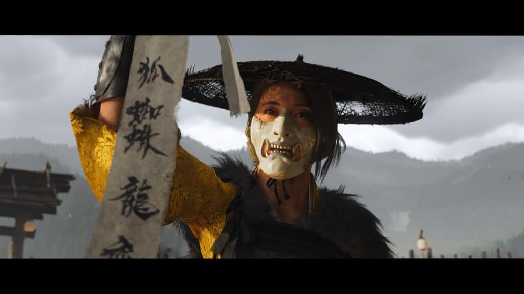 A masked figure in a straw hat, known as the Ghost of Yotei, holds a scroll with Japanese writing against a cloudy outdoor backdrop.