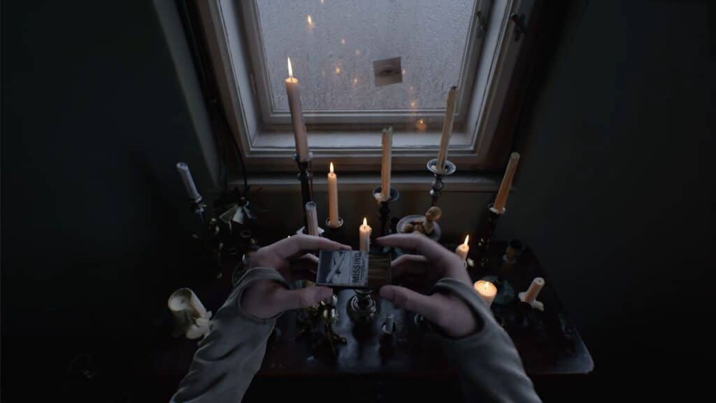 Hands holding a matchbox above a candlelit table by a window with raindrops outside, as the soft glow flickers in a scene from OD Knock from Kojima Productions.