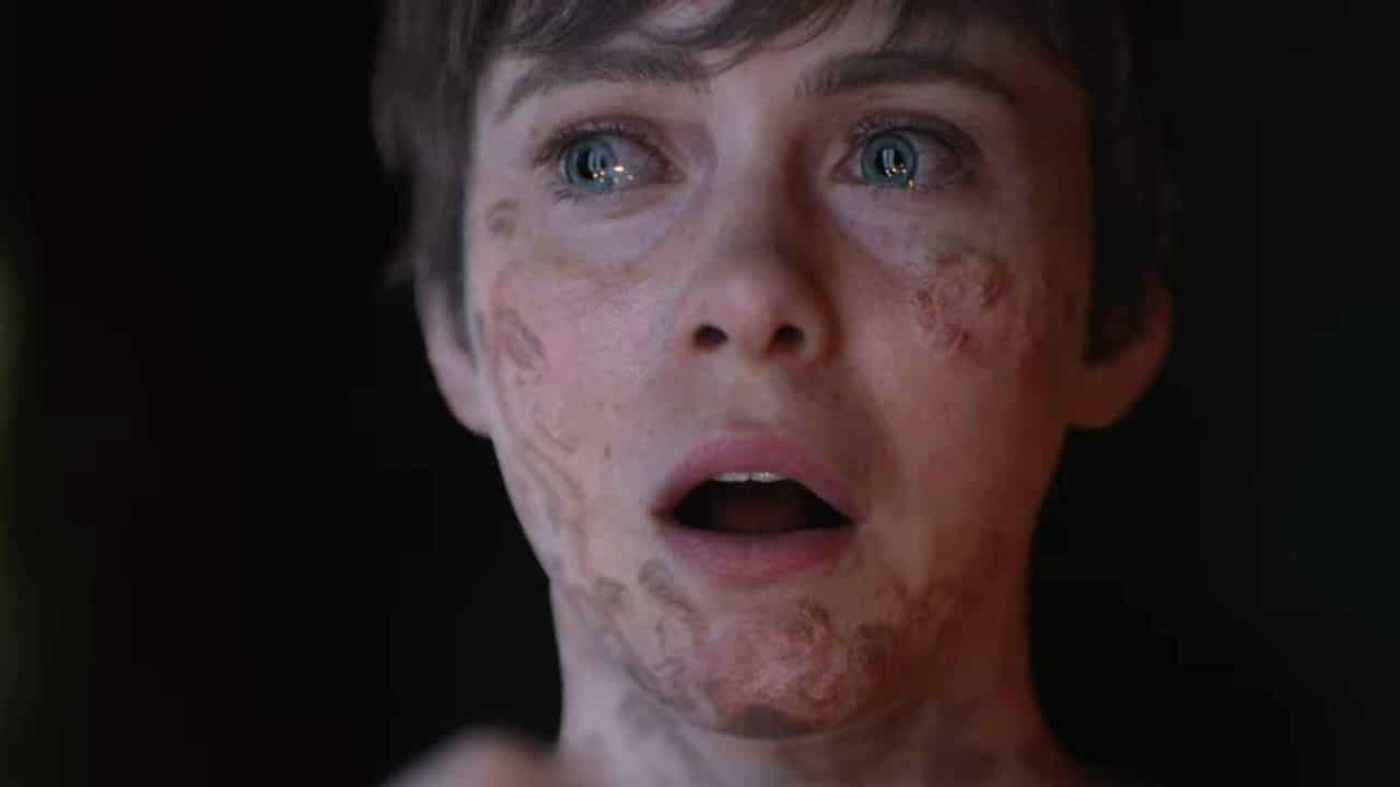 Person with short hair and facial scars looks ahead with a shocked expression, mouth slightly open, in a brand new trailer for OD Knock from Kojima Productions.