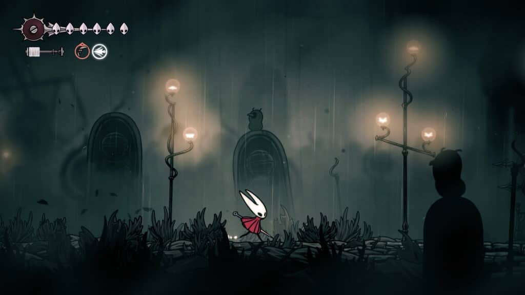 A white bug-like character with a red cloak stands in a dark, misty, lamp-lit environment from the Hollow Knight Silksong video game.