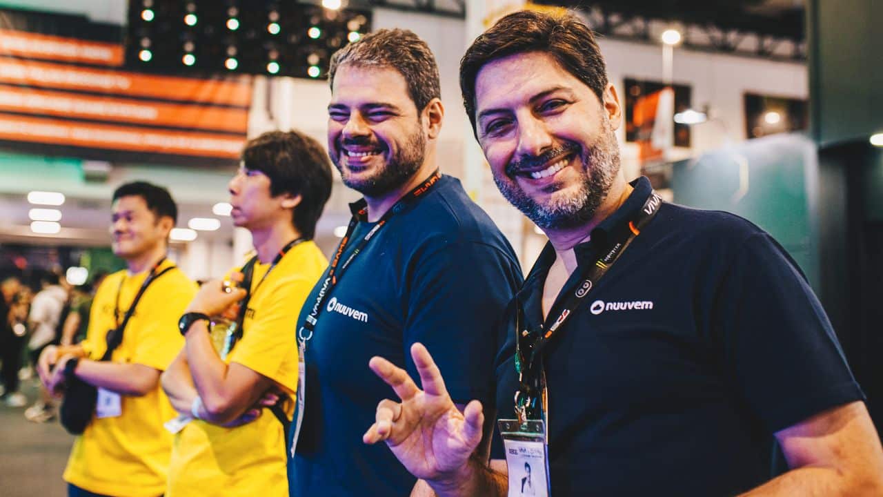 Fernando Campos smiling at an indoor event, in a blue Nuuvem shirt with badge, gathered after a Nuuvem spawnd interview.