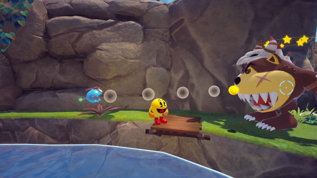 In Pac-Man World 2: Re-Pac, Pac-Man faces a large, cartoonish monster by a riverbank in a colorful, rocky landscape.