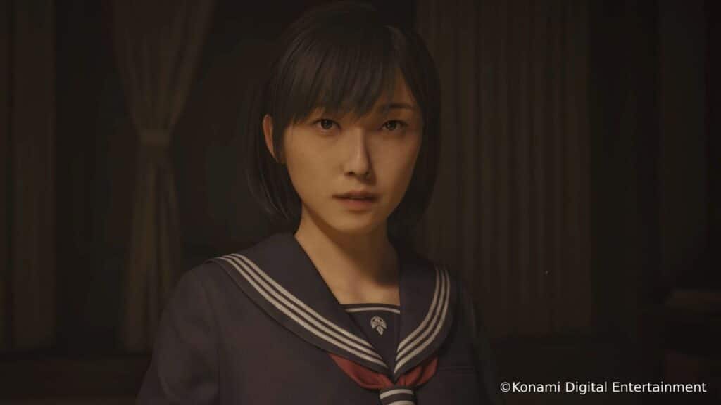 A girl in a navy blue school uniform stands indoors, looking forward with a serious expression, evoking the haunting atmosphere of Silent Hill f.