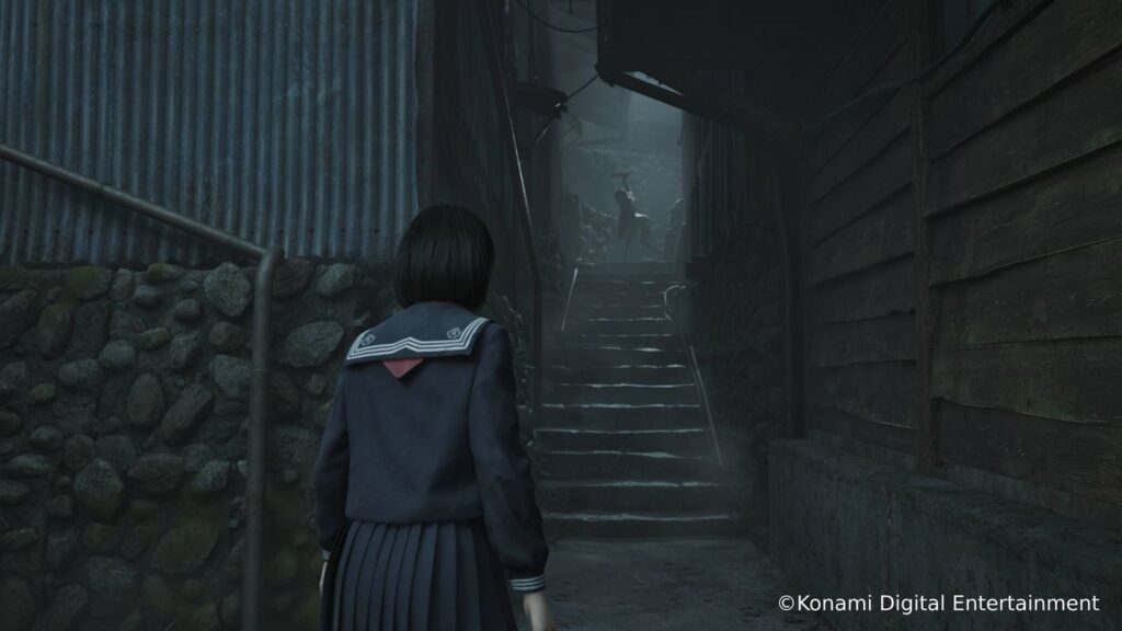 A girl in a school uniform stands at the bottom of dark, stone steps in a narrow alleyway, evoking the eerie atmosphere of Silent Hill f.