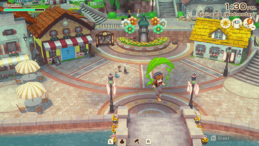 A colorful scene from the game 'Story of Seasons: Grand Bazaar', showcasing a character gliding with a green parachute over a vibrant town square featuring various buildings, flower decorations, and umbrellas.