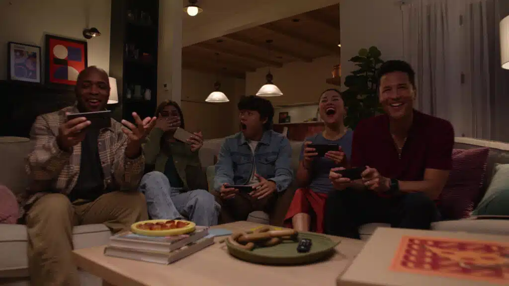 Friends playing games together using Amazon Luna on their phones in a living room