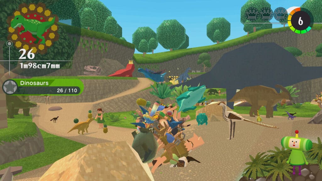 Colorful video game scene from Once Upon A KATAMARI, featuring dinosaurs, trees, and a ball collecting various objects in a vibrant prehistoric setting.