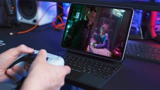 A person using a controller to play a Cyberpunk 2077 on the tablet via cloud gaming