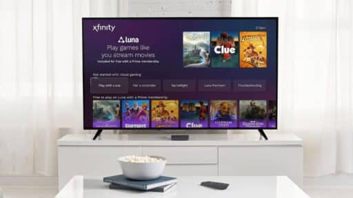 A TV screen displays Amazon Luna on Rogers Xfinity game options; a bowl of popcorn and remote sit on a white table in front.