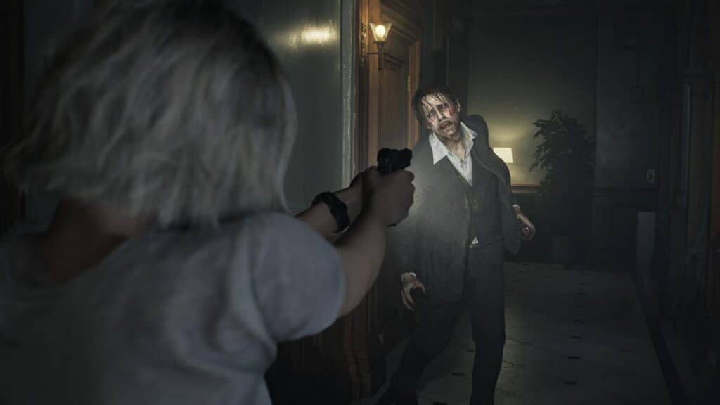 In this Resident Evil Requiem preview, a person aims a gun at a zombie lurking in a dimly lit hallway.
